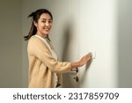 Earth Hour. Asian beautiful woman turn off or on the light to saving electrical energy. Finger pushing light switch turn on or off. White switch
