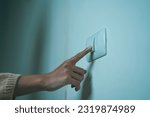 Earth Hour Close up woman finger turn off or on the light to saving electrical energy. Finger pushing light switch turn on or off. White switch