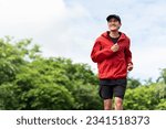 Attractive Young indian man wearing sportswear running on track at sport stadium. Asian Fit man jogging outdoor cross the finish line. Exercise in the morning. Healthy and active lifestyle concept.