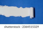 Small photo of Torn blue paper sheet isolated on white background