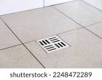 Small photo of Water drain hole. Clean bathroom sewer trap. Close-up. Shower sewerage. Bath plug. Metallic grate. Anti-odor. Valve. Gray tile. Copy space.