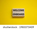Welcome onboard symbol. Wooden blocks with words 'Welcome onboard' on beautiful yellow background. Business and welcome onboard concept. Copy space.