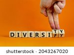 Small photo of Diversity or diversify symbol. Businessman turns wooden cubes and changes the word 'diversify' to 'diversity'. Beautiful orange background, copy space. Business and diversity or diversify concept.