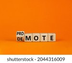 Small photo of Promote or demote symbol. Turned a cube and changed the word 'demote' to 'promote'. Beautiful orange table, orange background. Business, demote or promote concept. Copy space.