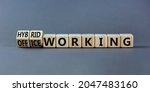 Small photo of Hybrid or office working symbol. Turned wooden cubes and changed words 'office working' to 'hybrid working'. Beautiful grey background. Business, hybrid or office working concept, copy space.