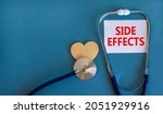 Small photo of Side effects symbol. White card with words Side effects, beautiful blue background, wooden heart and stethoscope. Medical and side effects concept.