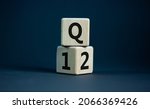 Small photo of From 1st to 2nd quarter symbol. Turned wooden cubes and changed words 'Q1' to 'Q2'. Beautiful grey table, grey background. Business, happy 2nd quarter Q2 concept, copy space.