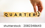 Small photo of From 4th to 1st quarter symbol. Businessman turns a cube and changes words 'quarter 4' to 'quarter 1'. Beautiful white table, white background. Business, happy 1st quarter concept, copy space.