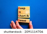Small photo of KISS keep it short and sweet symbol. Concept words KISS keep it short and sweet wooden blocks. Beautiful blue table, blue background. Business and KISS keep it short and sweet concept. Copy space.