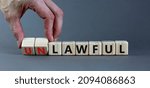 Small photo of Lawful or unlawful symbol. Businessman turns wooden cubes and changes the word unlawful to lawful. Beautiful grey table, grey background, copy space. Business and lawful or unlawful concept.