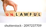 Small photo of Lawful or unlawful symbol. Businessman turns wooden cubes and changes the word unlawful to lawful. Beautiful white table, white background, copy space. Business and lawful or unlawful concept.
