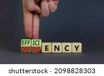 Small photo of Efficiency or dependency symbol. Businessman turns cubes, changes the word dependency to efficiency. Beautiful grey table, grey background, copy space. Business, efficiency or dependency concept.