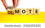 Small photo of Promote or demote symbol. Businessman turns a cube and changes the word 'demote' to 'promote'. Beautiful yellow table, white background. Business, demote or promote concept. Copy space.