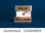 Small photo of Hello and welcome symbol. Concept words Hello and welcome on wooden blocks. Beautiful grey background. Business hello and welcome concept. Copy space.