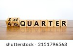Small photo of From 4th forth to 1st first quarter symbol. Turned wooden cubes and changed words 4th quarter to 1st quarter. Beautiful wooden table white background. Business happy 1st quarter concept, copy space.