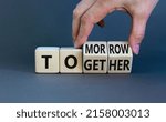 Small photo of Tomorrow we will together symbol. Businessman turns wooden cubes and changes the word together to tomorrow. Beautiful grey background, copy space. Business and tomorrow we are together concept.