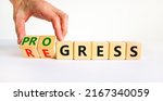 Small photo of Regress or progress symbol. Businessman turns wooden cubes and changes the word 'regress' to 'progress'. Beautiful white table, white background, copy space. Business, regress or progress concept.