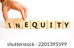 Small photo of Inequity or equity symbol. Businessman turns wooden cubes and changes the word inequity to equity. Business and inequity or equity concept. Beautiful white background, copy space.