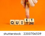 Quiet quitting symbol. Concept words Quiet quitting on wooden cubes. Businessman hand. Beautiful orange table orange background. Business quiet quitting concept. Copy space.