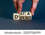 Data defence symbol. Concept words Data defence on wooden cubes. Beautiful grey table grey background. Businessman hand. Business and cyber crime concept. Copy space.