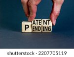 Small photo of Patent pending symbol. Concept words Patent pending on wooden cubes. Businessman hand. Beautiful grey table grey background. Business and patent pending concept. Copy space.