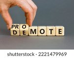 Small photo of Promote or demote symbol. Businessman turns cubes and changes the word 'demote' to 'promote'. Beautiful grey background. Business, demote or promote concept. Copy space.