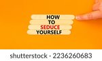 Small photo of How to seduce yourself symbol. Concept word How to seduce yourself on wooden sticks. Businessman hand. Beautiful orange table orange background. Business and how to seduce yourself concept. Copy space