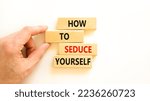 Small photo of How to seduce yourself symbol. Concept word How to seduce yourself on wooden blocks. Businessman hand. Beautiful white table white background. Business and how to seduce yourself concept. Copy space.