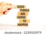 Small photo of Good things happen symbol. Concept words Good things are going to happen on wooden blocks on a beautiful white table white background. Businessman hand. Business good things happen concept.