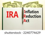 Small photo of IRA inflation reduction act symbol. Concept words IRA inflation reduction act on white note on a beautiful background from dollar bills. Business IRA inflation reduction act concept. Copy space.
