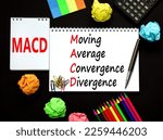 Small photo of MACD symbol. Concept words MACD moving average convergence divergence on white note on beautiful black background. Business MACD moving average convergence divergence concept. Copy space.
