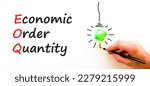 Small photo of EOQ economic order quantity symbol. Concept words EOQ economic order quantity on paper on a beautiful white background. Green light bulb icon. Business EOQ economic order quantity concept. Copy space.