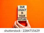 Small photo of Legacy and future symbol. Concept words Our legacy is your future on wooden blocks. Beautiful orange table orange background. Businessman hand. Business legacy and future concept. Copy space.