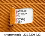 Small photo of ARPPU average revenue per paying user symbol. Concept words ARPPU average revenue per paying user on white paper. Beautiful brown background. Business ARPPU average revenue per paying user concept.