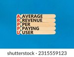 Small photo of ARPPU average revenue per paying user symbol. Concept words ARPPU average revenue per paying user on wood stick. Beautiful blue background. Business ARPPU average revenue per paying user concept.
