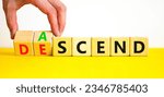 Small photo of Ascend or descend symbol. Concept words Ascend and Descend on wooden cubes. Beautiful yellow table white background. Businessman hand. Business ascend or descend concept. Copy space.