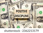 Small photo of Positive discipline symbol. Concept words Positive discipline on beautiful blocks. Dollar bills. Beautiful background from dollar bills. Business psychology positive discipline concept. Copy space.