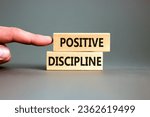 Small photo of Positive discipline symbol. Concept words Positive discipline on beautiful wooden blocks. Beautiful grey background. Businessman hand. Business psychology positive discipline concept. Copy space.