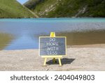 Small photo of Do more with less symbol. Concept word Do more with less on beautiful black chalk blackboard. Beautiful mountain lake background. Business do more with less concept. Copy space.