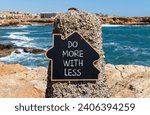 Small photo of Do more with less symbol. Concept word Do more with less on beautiful black chalk blackboard. Beautiful red stone blue sea background. Business do more with less concept. Copy space.