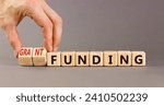 Small photo of Grant funding symbol. Concept words Grant funding on beautiful wooden blocks. Beautiful grey table grey background. Businessman hand. Business and grant funding concept. Copy space.