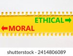Small photo of Ethical or moral symbol. Concept word Ethical or Moral on beautiful yellow paper. Beautiful white paper background. Business and ethical or moral concept. Copy space.