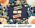 Small photo of Anything is possible symbol. Concept words Anything is possible on beautiful wooden blocks. Beautiful black table black background. Sea shell stone. Business anything possible concept. Copy space.