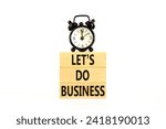 Small photo of let is do business symbol. Concept words let is do business on beautiful wooden blocks. Beautiful white table white background. Black alarm clock. let is do business concept. Copy space.