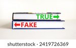 Small photo of True or fake symbol. Concept word True or Fake on beautiful books. Beautiful white table white background. Business and true or fake concept. Copy space.