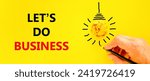 Small photo of let is do business symbol. Concept words let is do business on beautiful yellow paper. Beautiful yellow background. Light bulb icon. Businessman hand. let is do business concept. Copy space.
