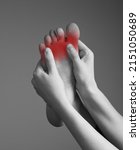 Small photo of Toe pain caused by overuse, injury, arthritis, bunion, calluses, tight shoes. Woman hands holding foot with red spot. Black and white. Orthopedic complaints and health problems concept