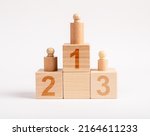 Small photo of Winners podium from wooden blocks with knobbed cylinders and numbers 1, 2, 3. Hierarchy, ranking concept. Distribution of places among competition champions. High quality photo