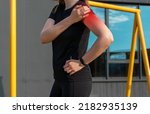 Small photo of Athlete touching painful shoulder with red point during outdoor training. Dislocation, arthritis, fracture, rotator cuff strain consequences. Health problems in sport concept. High quality photo