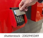 Hand paying with bank card at self-service ordering kiosk, machine, POS terminal. Cashless payment.